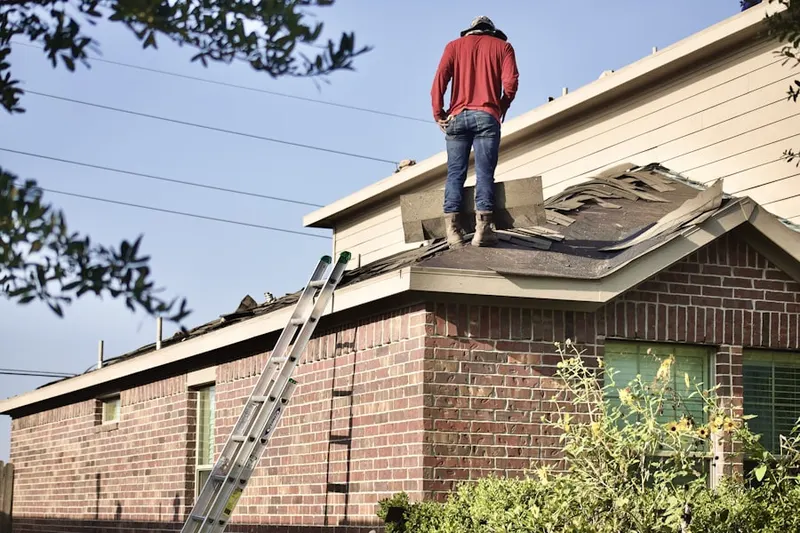 Professional roofer working on a residential roof in Wayland